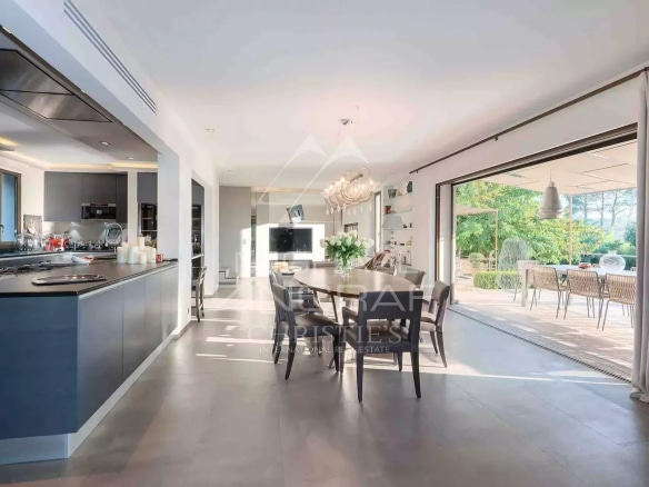 Interior of a renovated villa with a modern kitchen and a bright dining room.