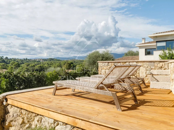 Terrasse en bois avec chaises longues, vue sur la nature et collines à Mougins.