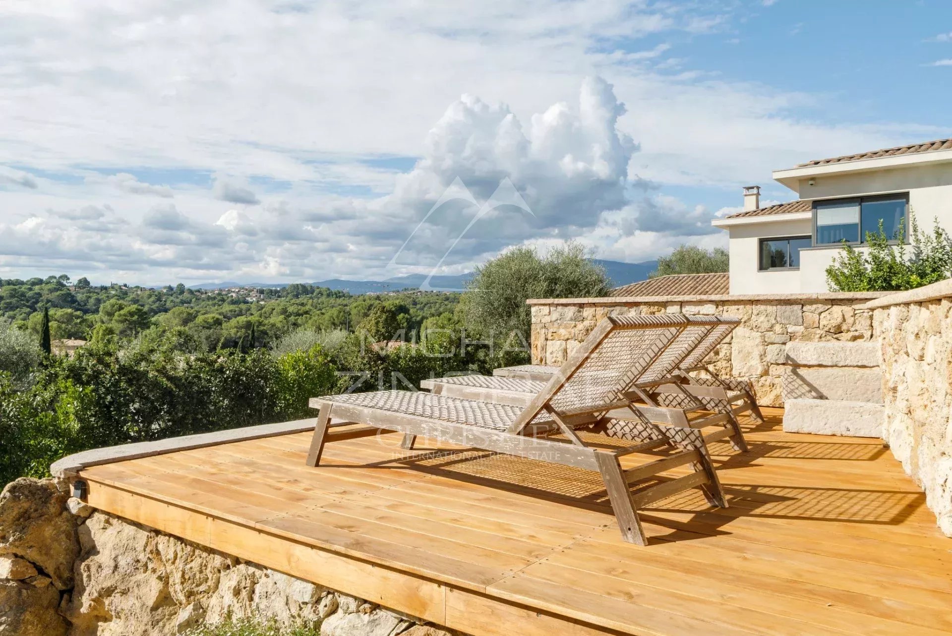 Terrasse en bois avec chaises longues, vue sur la nature et collines à Mougins.