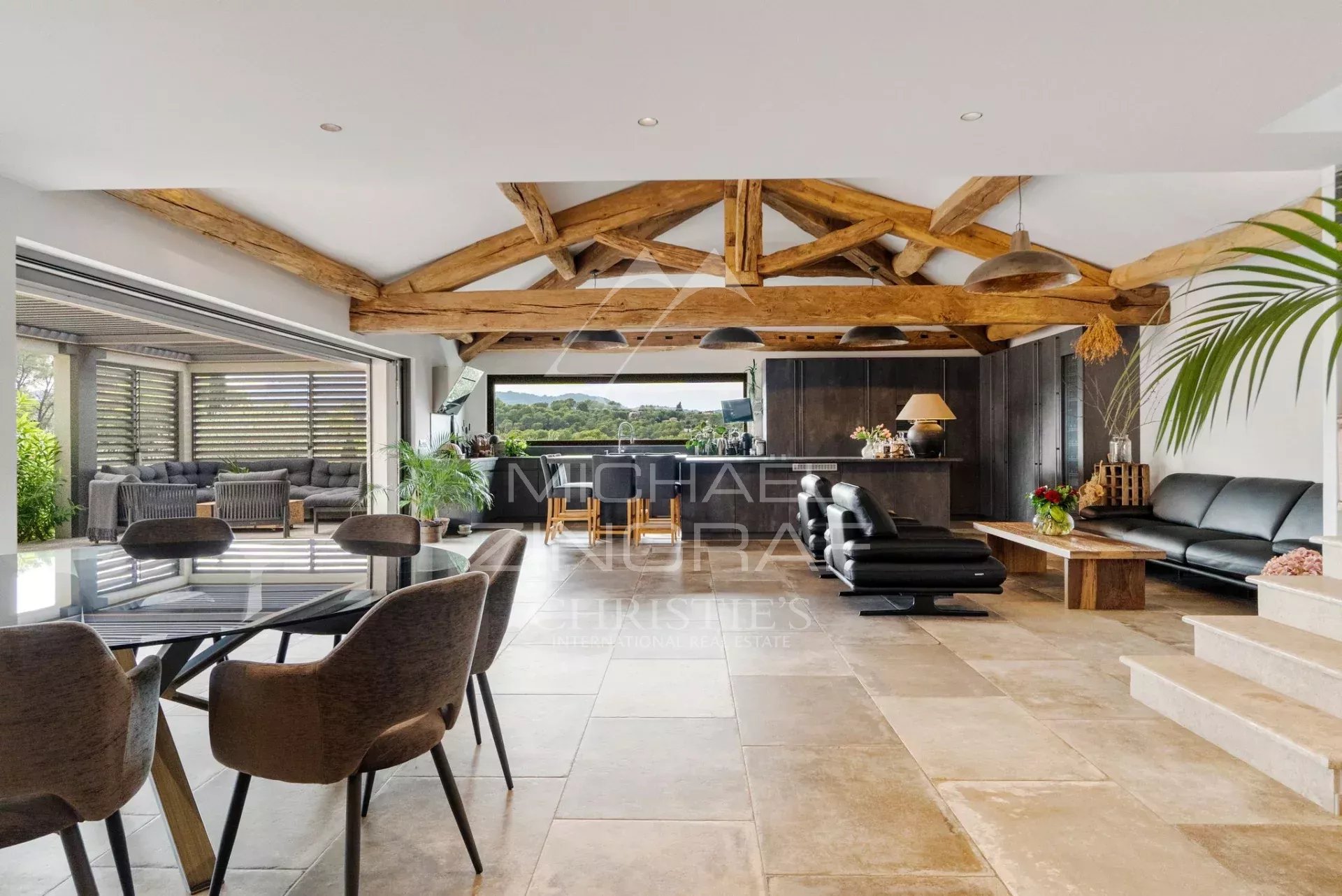 Intérieur d'une villa moderne avec poutres apparentes et espace de vie ouvert.