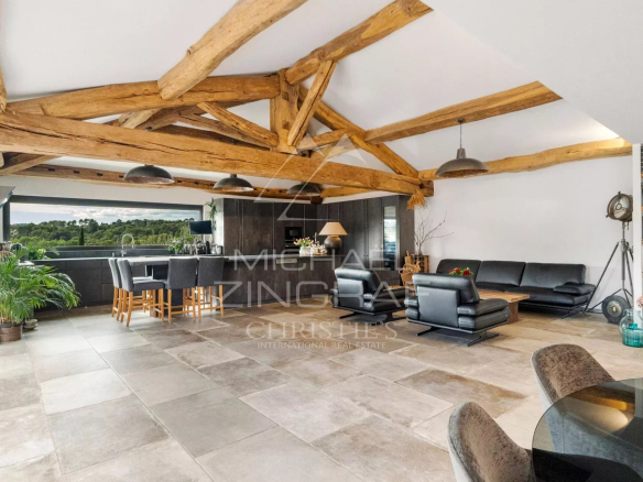 Intérieur d'une villa moderne avec poutres apparentes et espace de vie lumineux à Mougins.