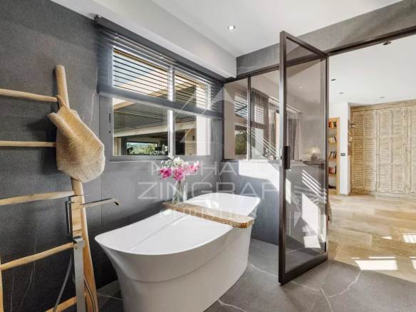 Salle de bain moderne avec baignoire et douche, décorée de matériaux contemporains.