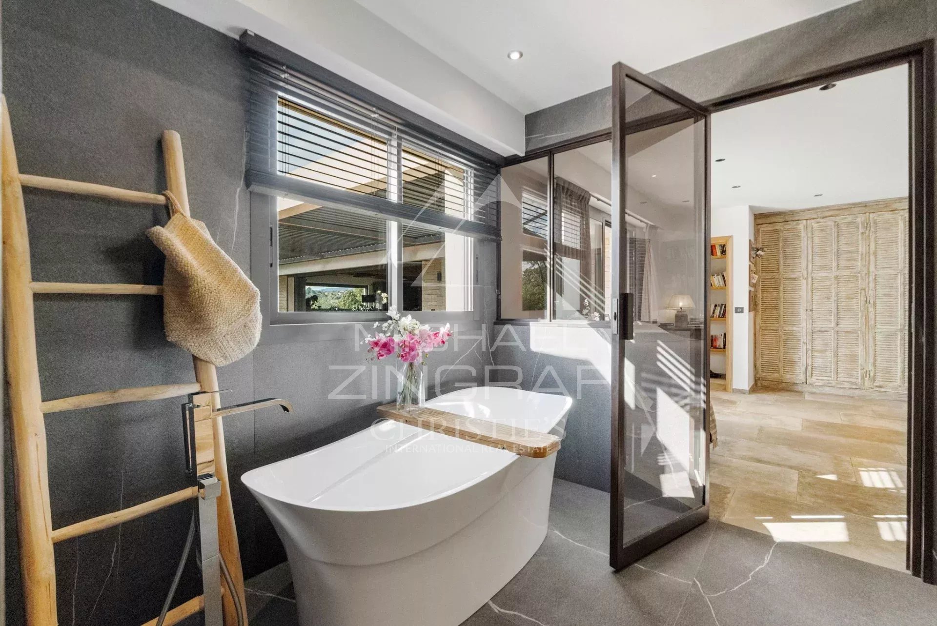 Salle de bain moderne avec baignoire et douche, décorée de matériaux contemporains.