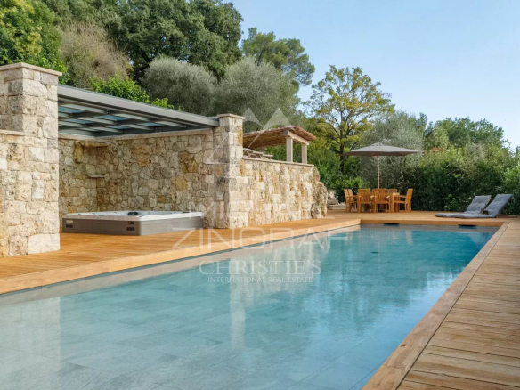 Vue de la piscine et de la terrasse en bois d'une villa récente à Mougins.