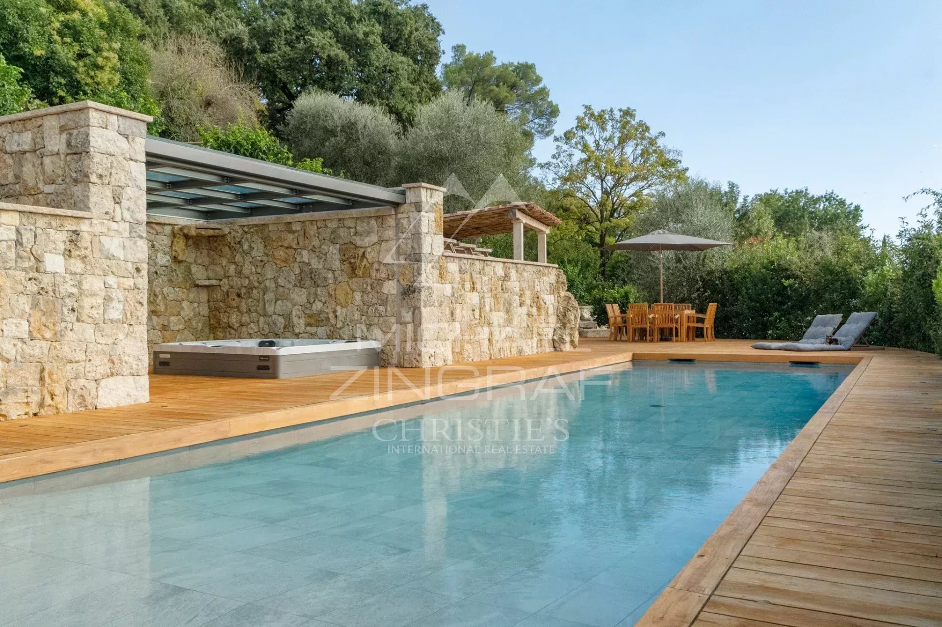 Vue de la piscine et de la terrasse en bois d'une villa récente à Mougins.