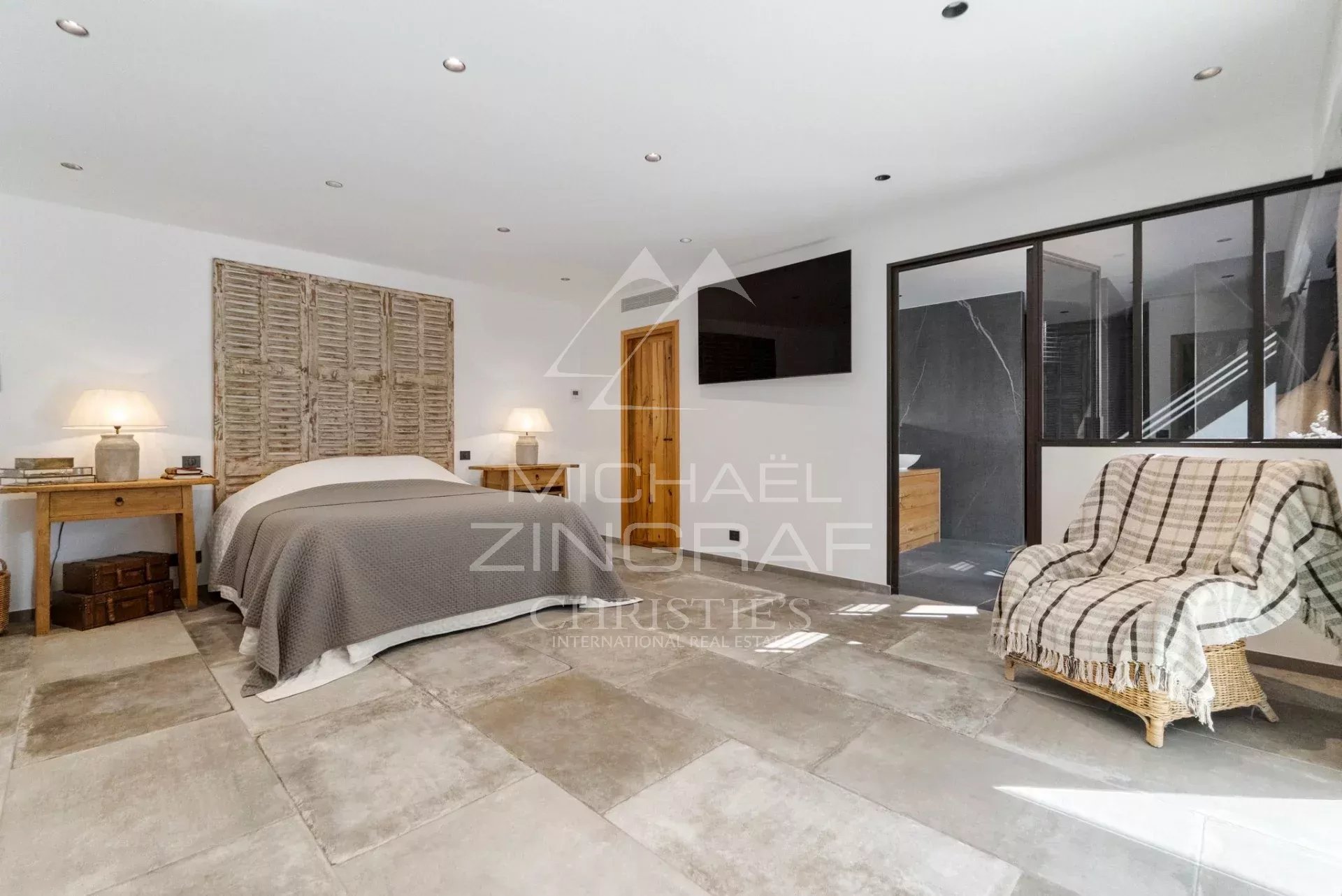 Chambre spacieuse avec lit, bureau et lumière naturelle dans une villa moderne