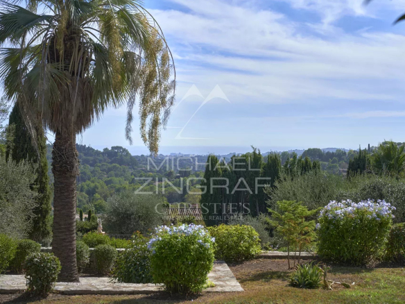 Unobstructed view of the hills and the old village of Mougins from a wooded area.