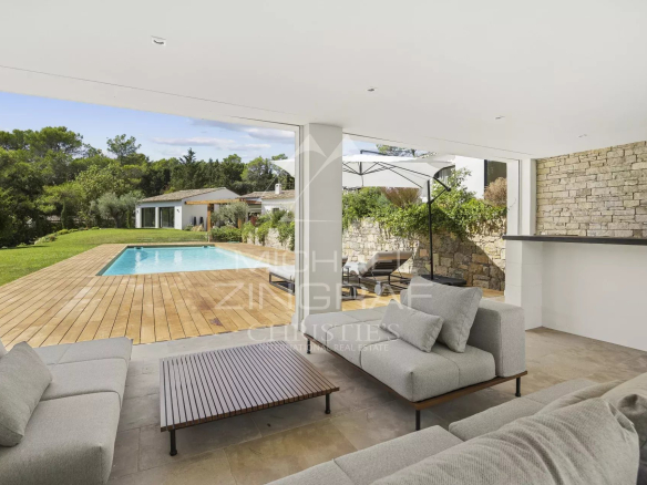 Terrasse d'une villa contemporaine avec piscine à Mougins, mobilier moderne et vue sur le jardin.