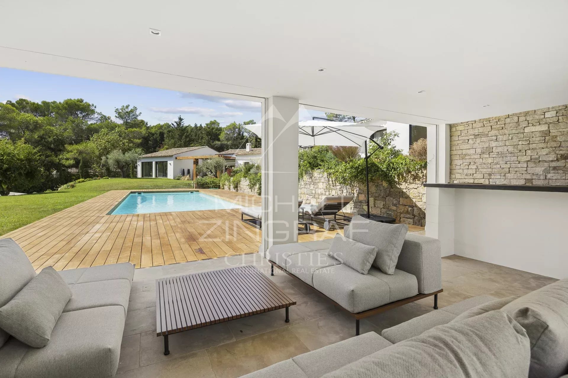 Villa contemporaine à Mougins Terrasse d'une villa contemporaine avec piscine à Mougins, mobilier moderne et vue sur le jardin.