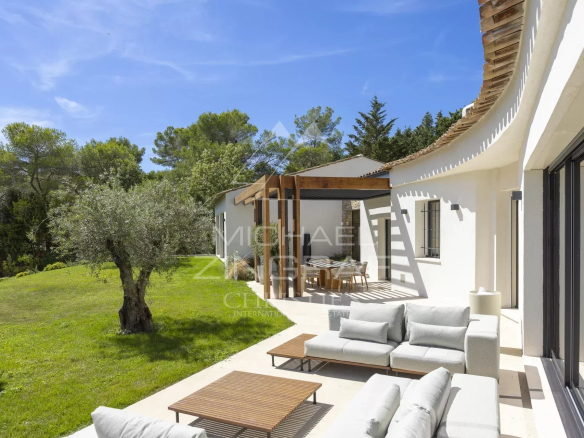 Terrasse d'une villa provençale contemporaine à Mougins avec mobilier extérieur et jardin verdoyant.