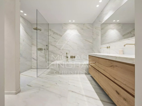 Salle de bain moderne avec carrelage en marbre et meuble en bois.