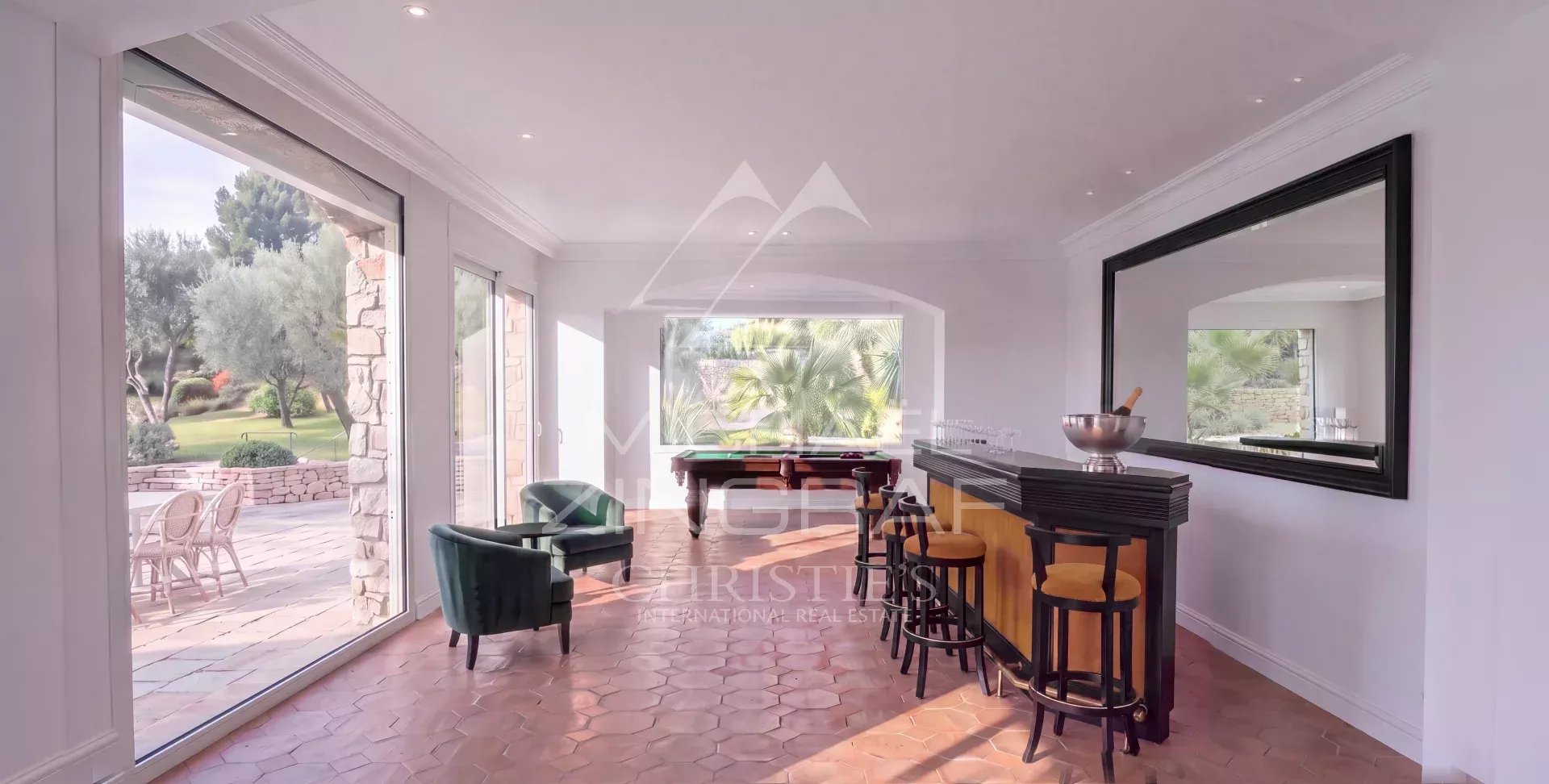 Intérieur d'une demeure élégante à Mougins avec bar et vue sur le parc paysager