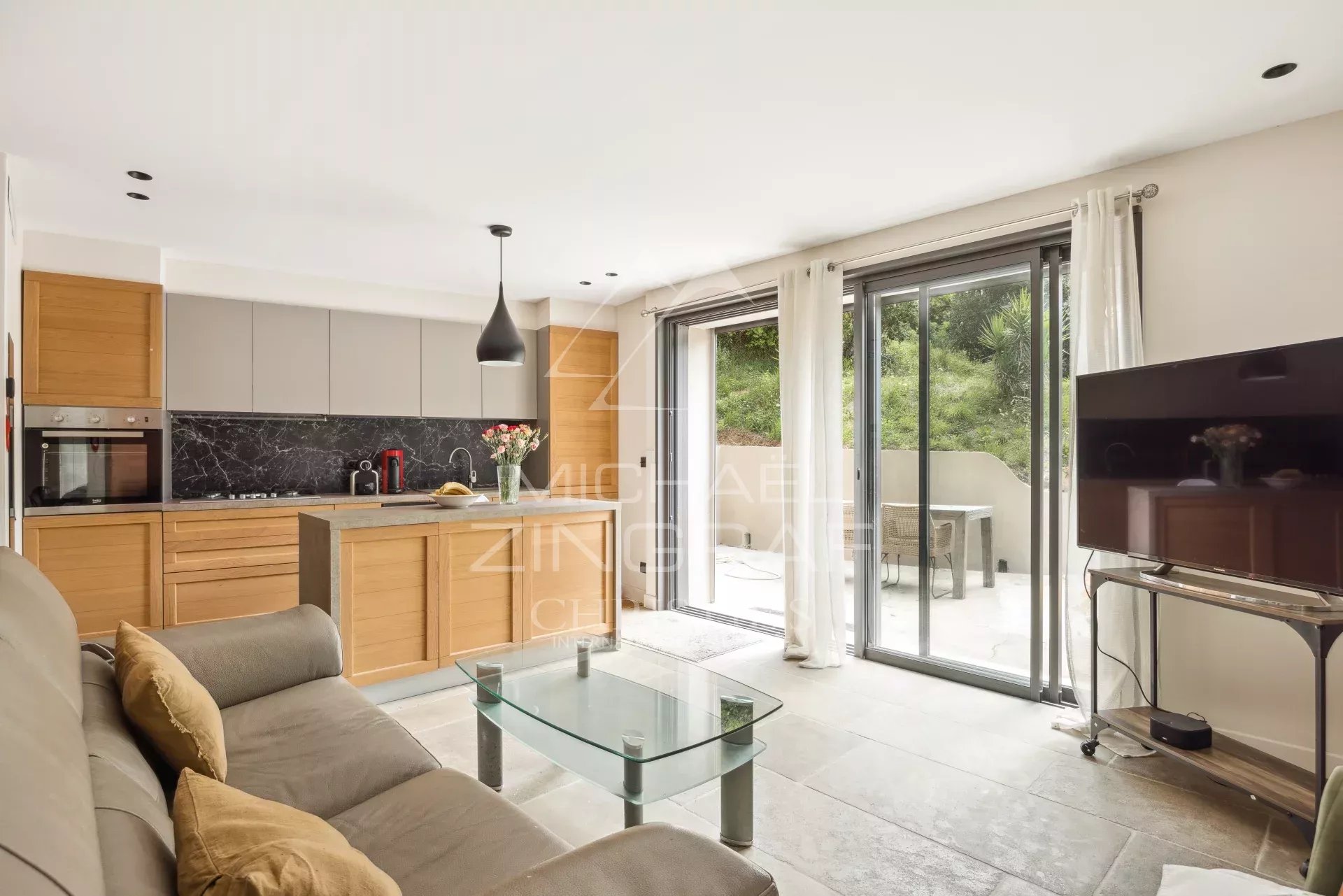 Intérieur d'une bastide rénovée avec cuisine moderne et salon lumineux.