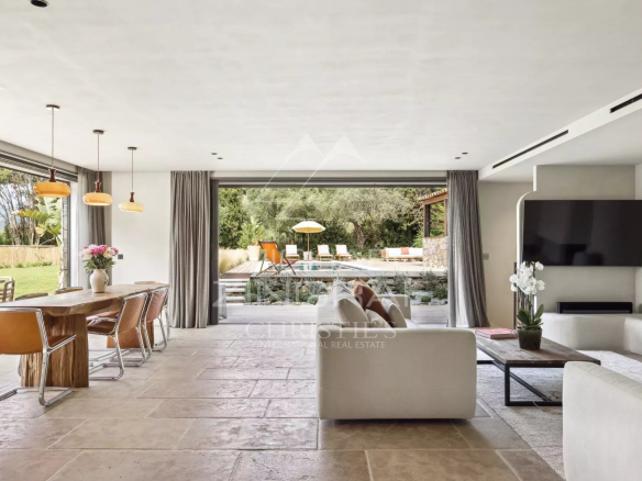 Intérieur d'une bastide rénovée avec salon lumineux et vue sur la piscine
