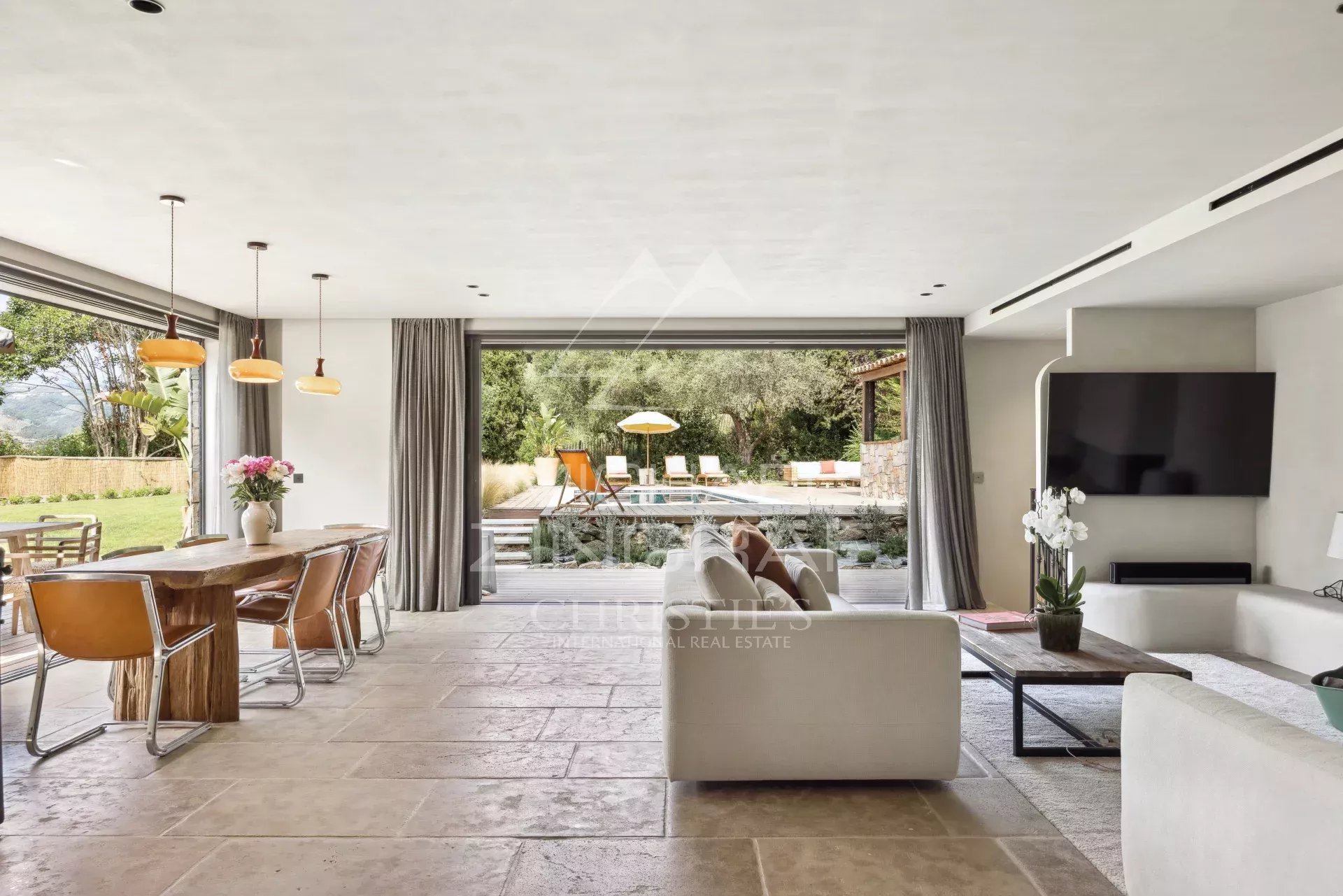Intérieur d'une bastide rénovée avec salon lumineux et vue sur la piscine