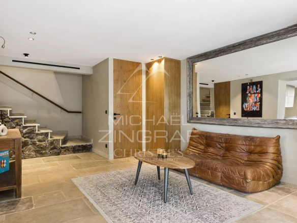 Intérieur d'une bastide rénovée avec un salon moderne et un escalier en pierre.