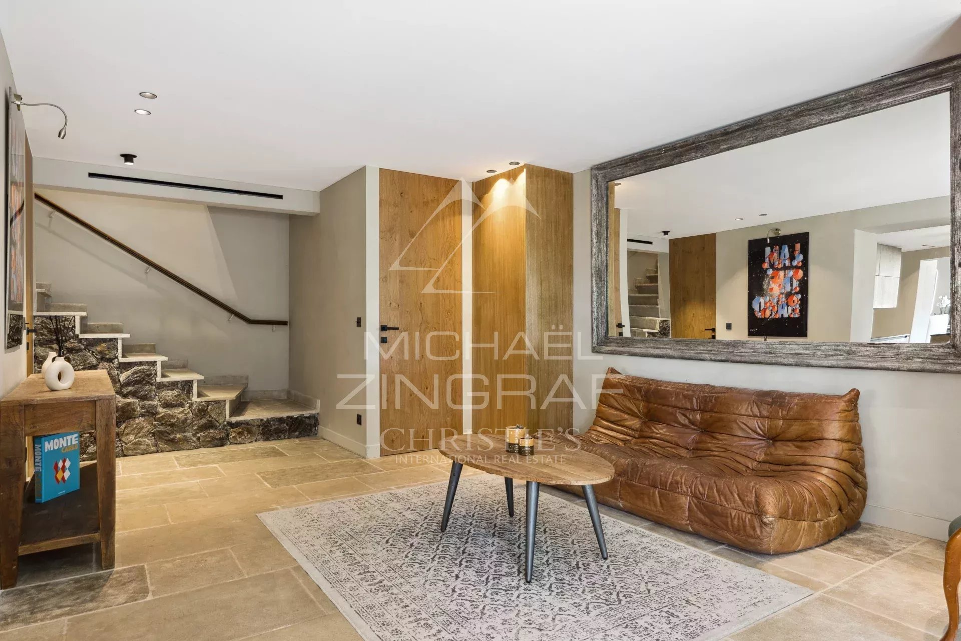 Intérieur d'une bastide rénovée avec un salon moderne et un escalier en pierre.