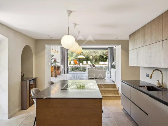 Cuisine moderne dans une bastide rénovée avec un espace repas et accès à l'extérieur.