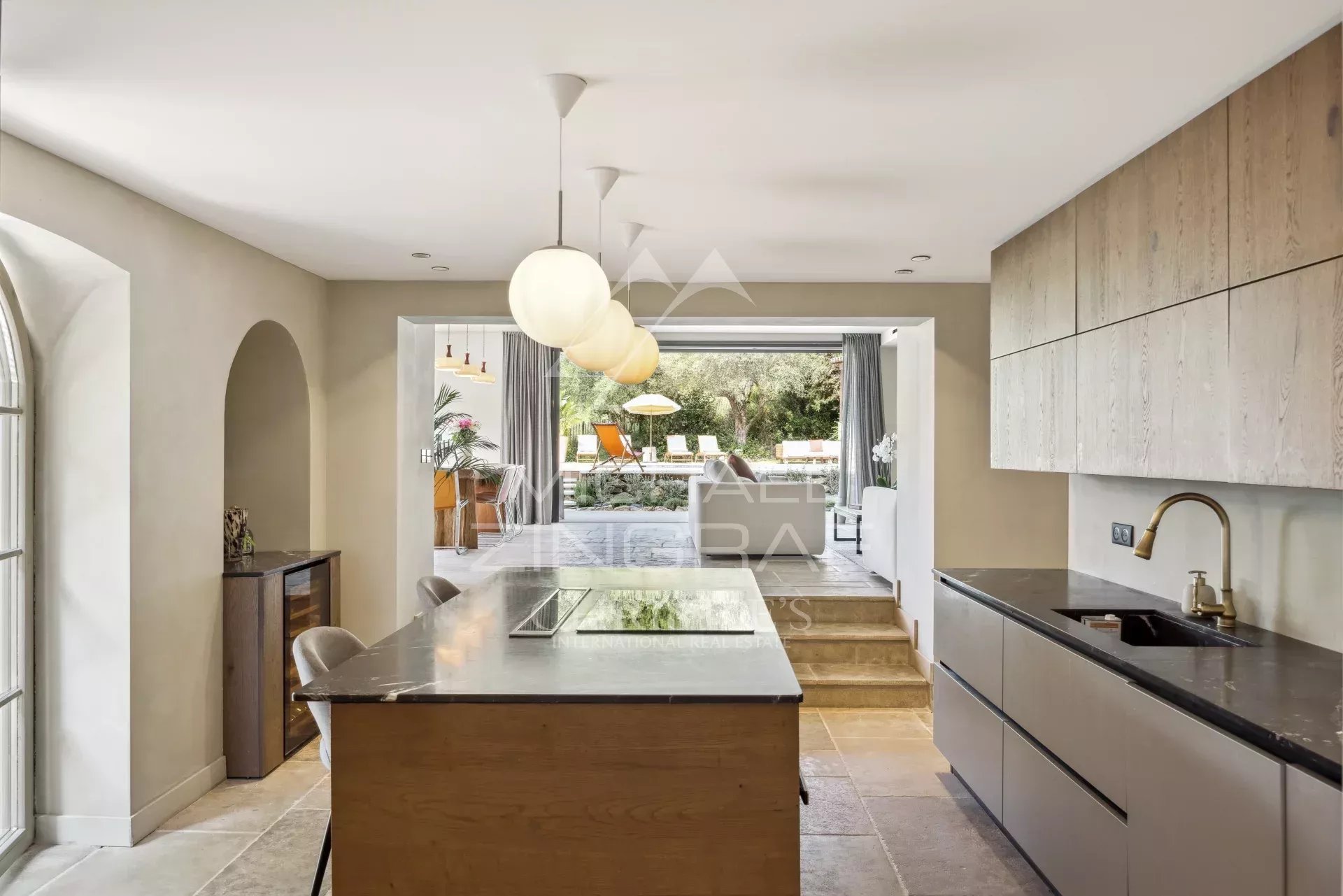 Cuisine moderne dans une bastide rénovée avec un espace repas et accès à l'extérieur.