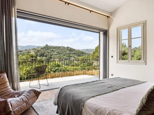 Chambre avec vue sur les collines, fenêtre ouverte, mobilier moderne
