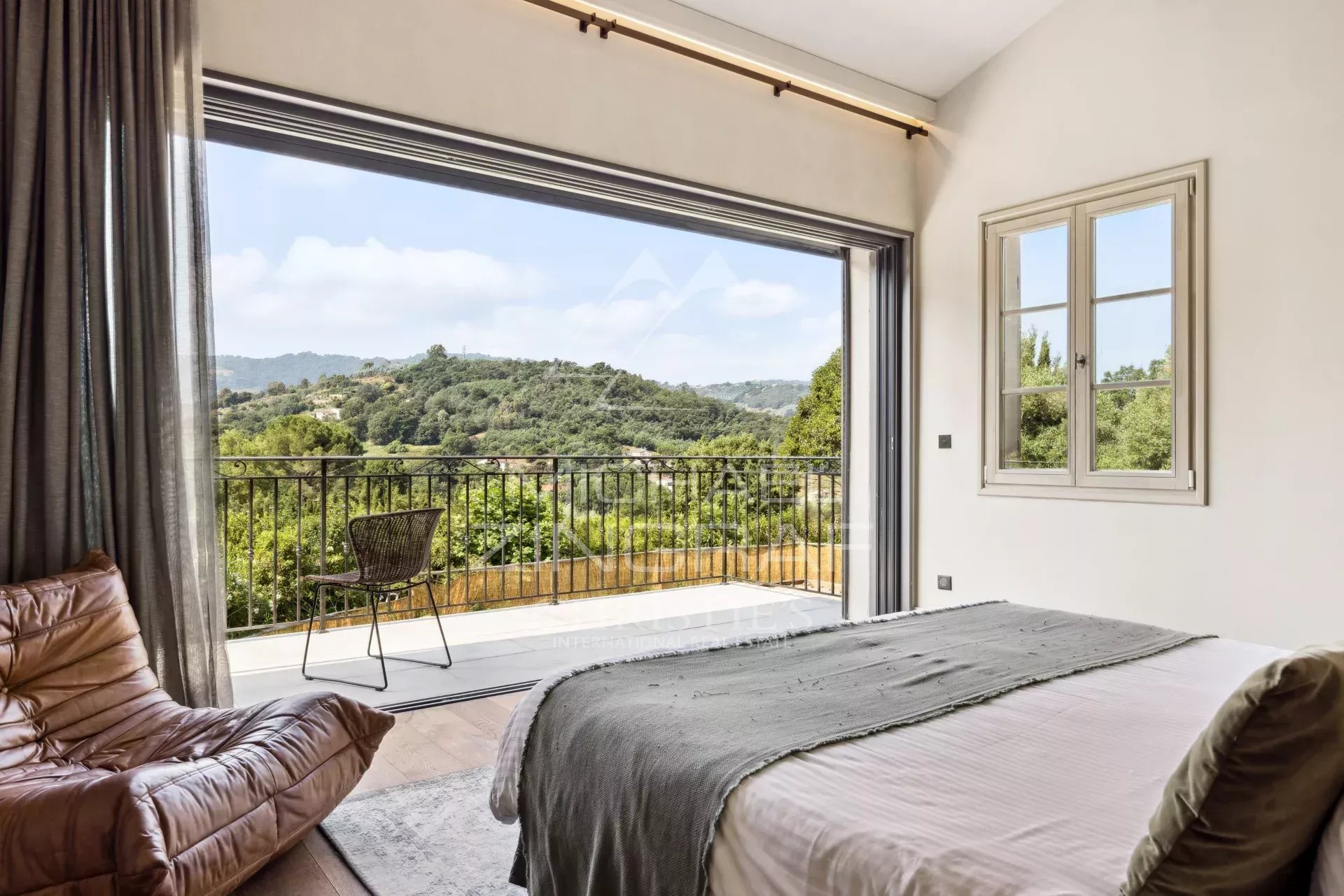 Chambre avec vue sur les collines, fenêtre ouverte, mobilier moderne