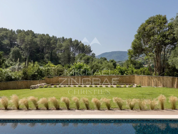 Vue d'un jardin paysager avec piscine, entouré d'arbres et de collines à Pégomas.