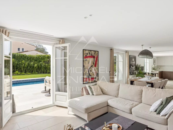 Interior of a renovated villa with a bright living room and access to the outdoor pool.