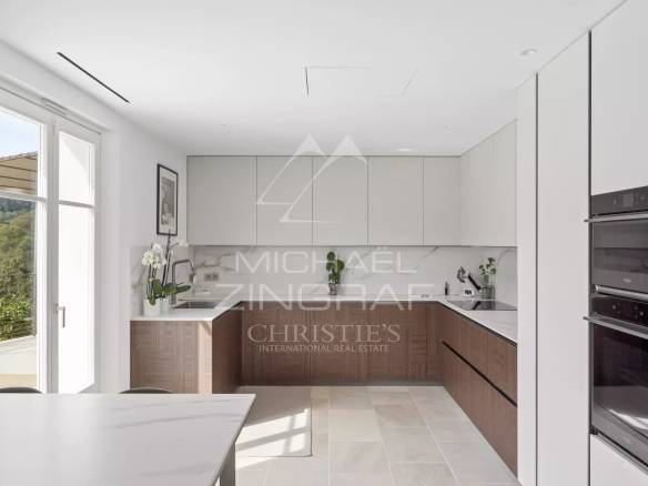 Modern and bright kitchen in a renovated villa in Mougins, with wooden and white elements.