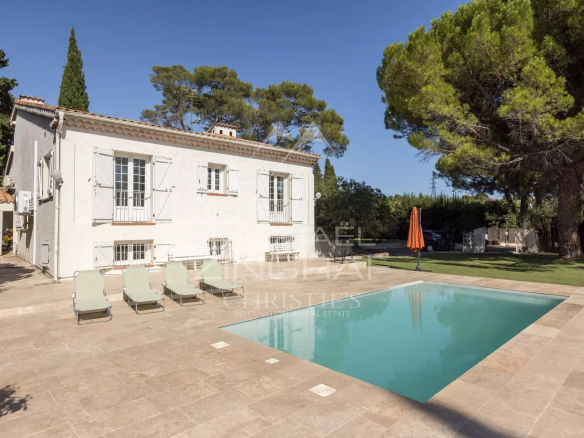 Villa familiale avec piscine et court de tennis à Mougins, entourée d'un jardin arboré.