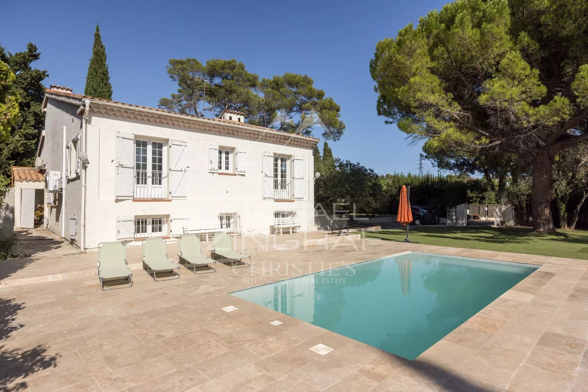 Villa avec piscine à Mougins Villa familiale avec piscine et court de tennis à Mougins, entourée d'un jardin arboré.