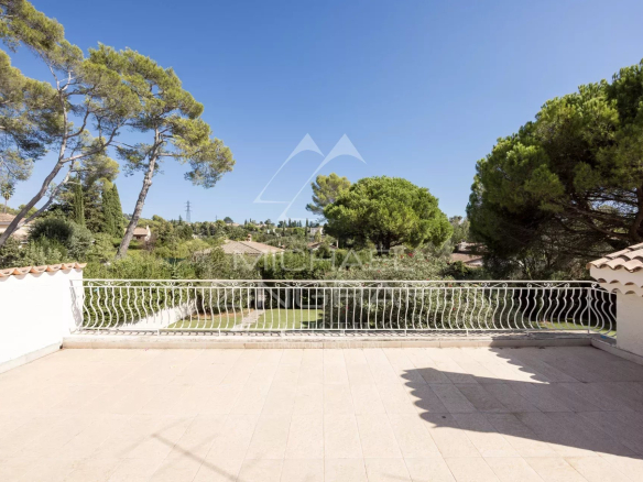 Terrasse d'une villa à Mougins avec vue sur un jardin et des arbres.