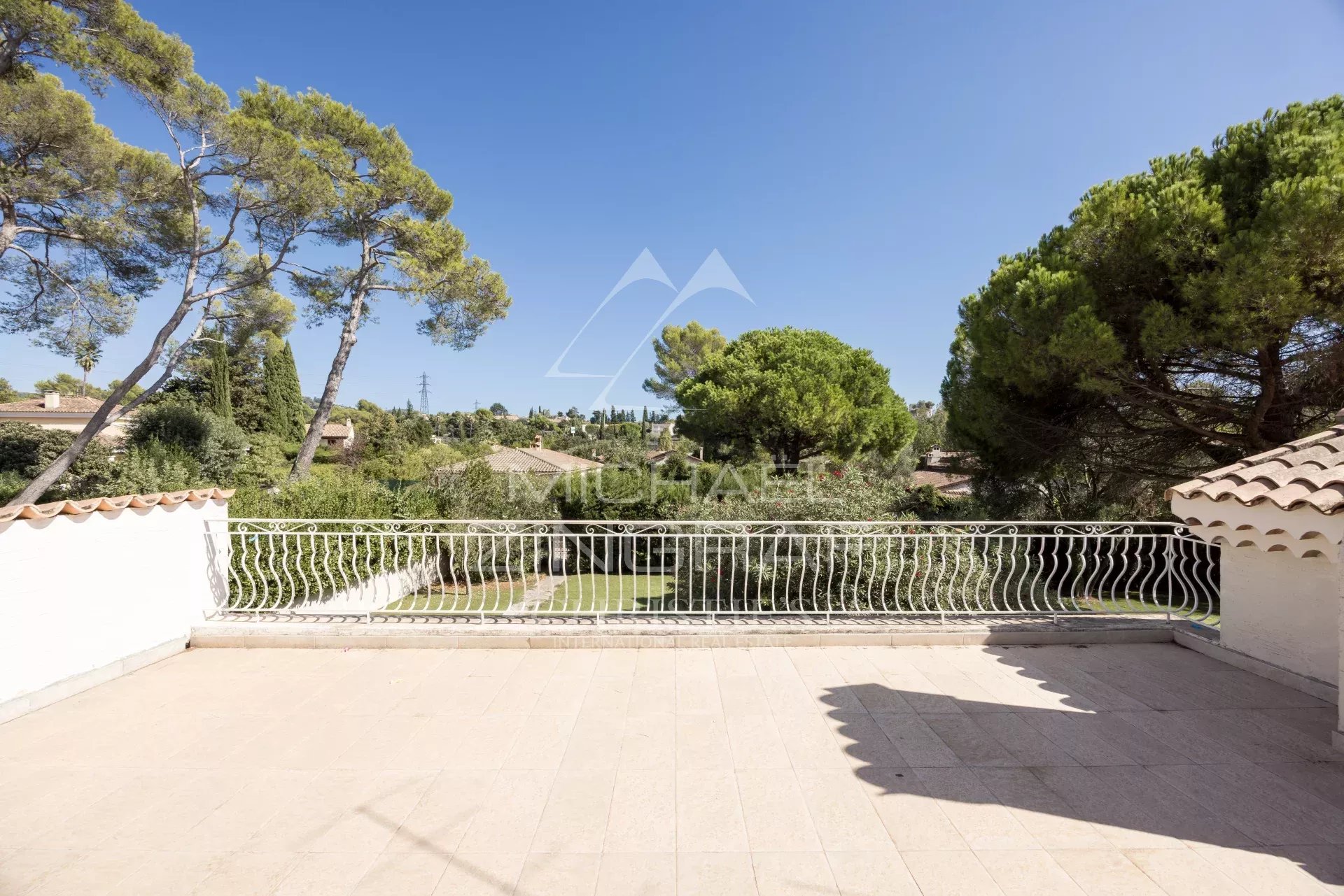 Terrasse de villa à Mougins Terrasse d'une villa à Mougins avec vue sur un jardin et des arbres.