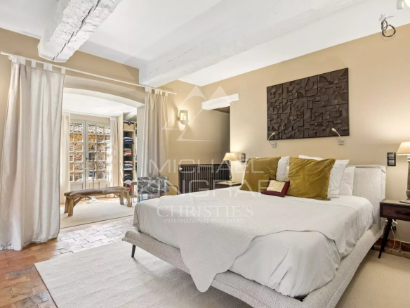 Chambre d'une propriété rénovée à Mouans-Sartoux avec lit double et décoration chaleureuse.