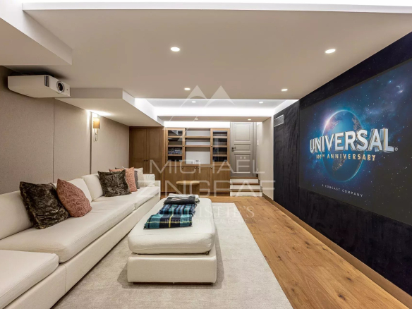 Intérieur d'une salle de cinéma avec canapé et écran de projection, décoration moderne.