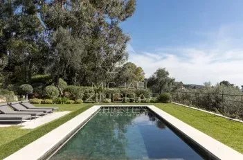 Vue panoramique d'une villa avec piscine et jardin à Mougins, entourée de verdure.