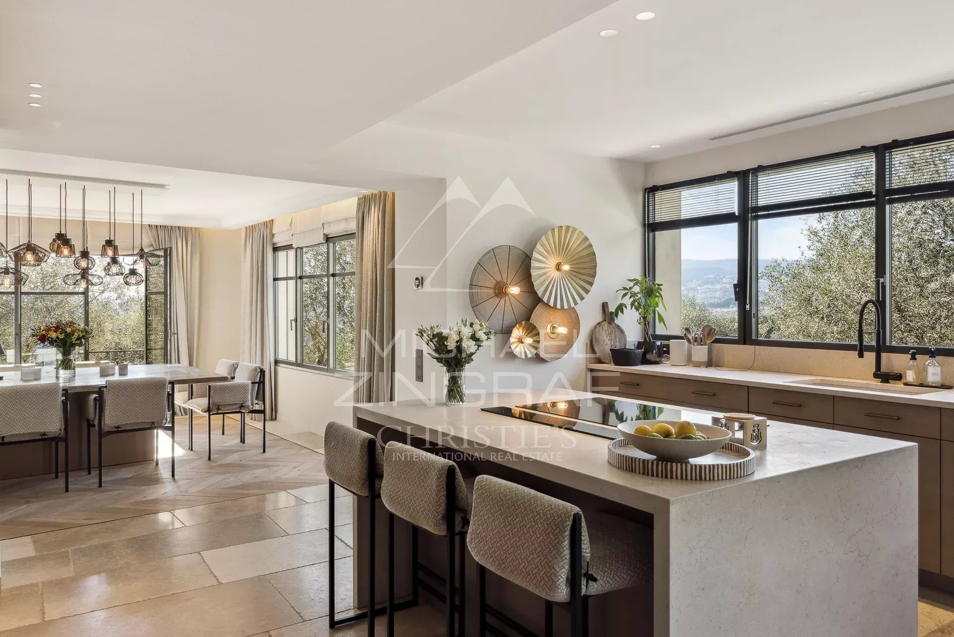 Intérieur d’une villa à Mougins Intérieur d'une villa moderne avec cuisine ouverte et vue sur la verdure.