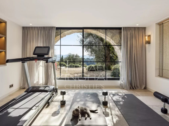 Intérieur d'une villa à Mougins avec vue panoramique, équipements de fitness et décoration moderne.
