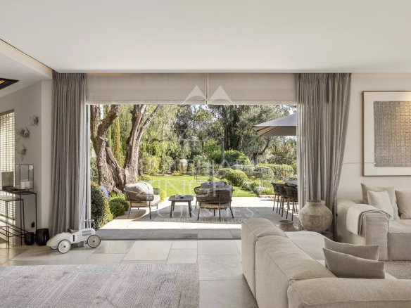 Intérieur d'une villa moderne avec vue sur un jardin verdoyant à Mougins.