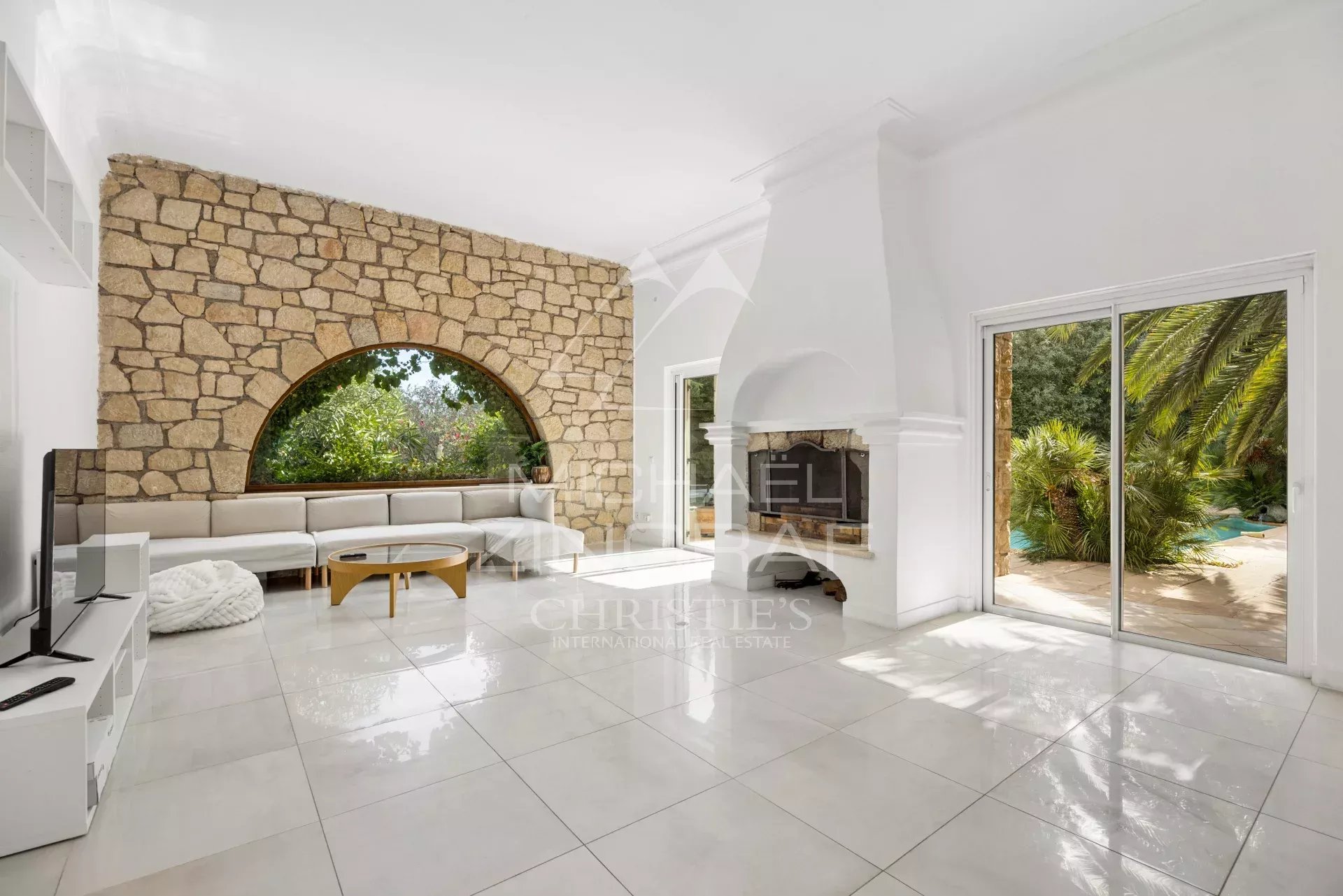 Interior of a Provençal villa in Mougins with a large, bright living room and a fireplace.
