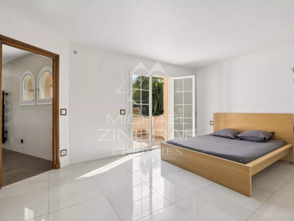 Room in a Provençal villa in Mougins with a wooden bed and access to the outside.
