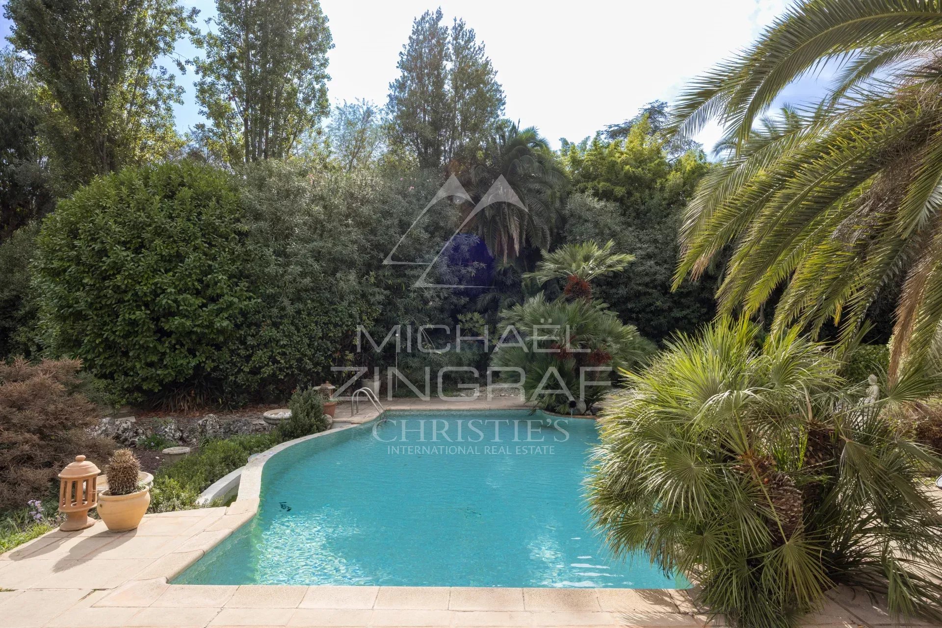 View of the swimming pool surrounded by greenery in a Provençal villa in Mougins.