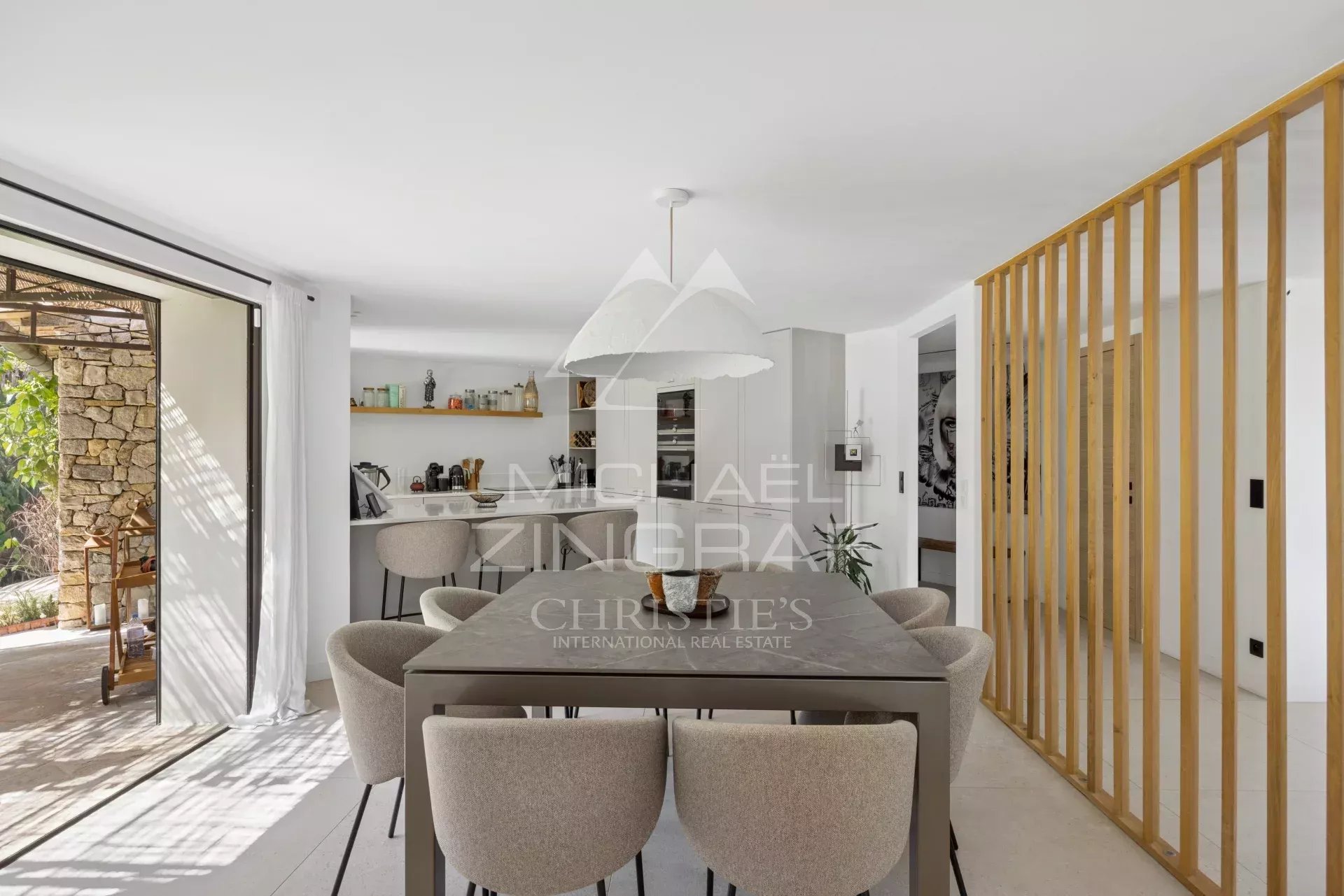 Intérieur d'une villa rénovée avec salle à manger moderne et accès à l'extérieur.