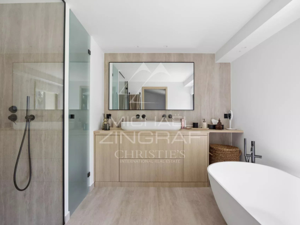 Salle de bains moderne avec baignoire et miroir, décorée avec des matériaux de qualité.
