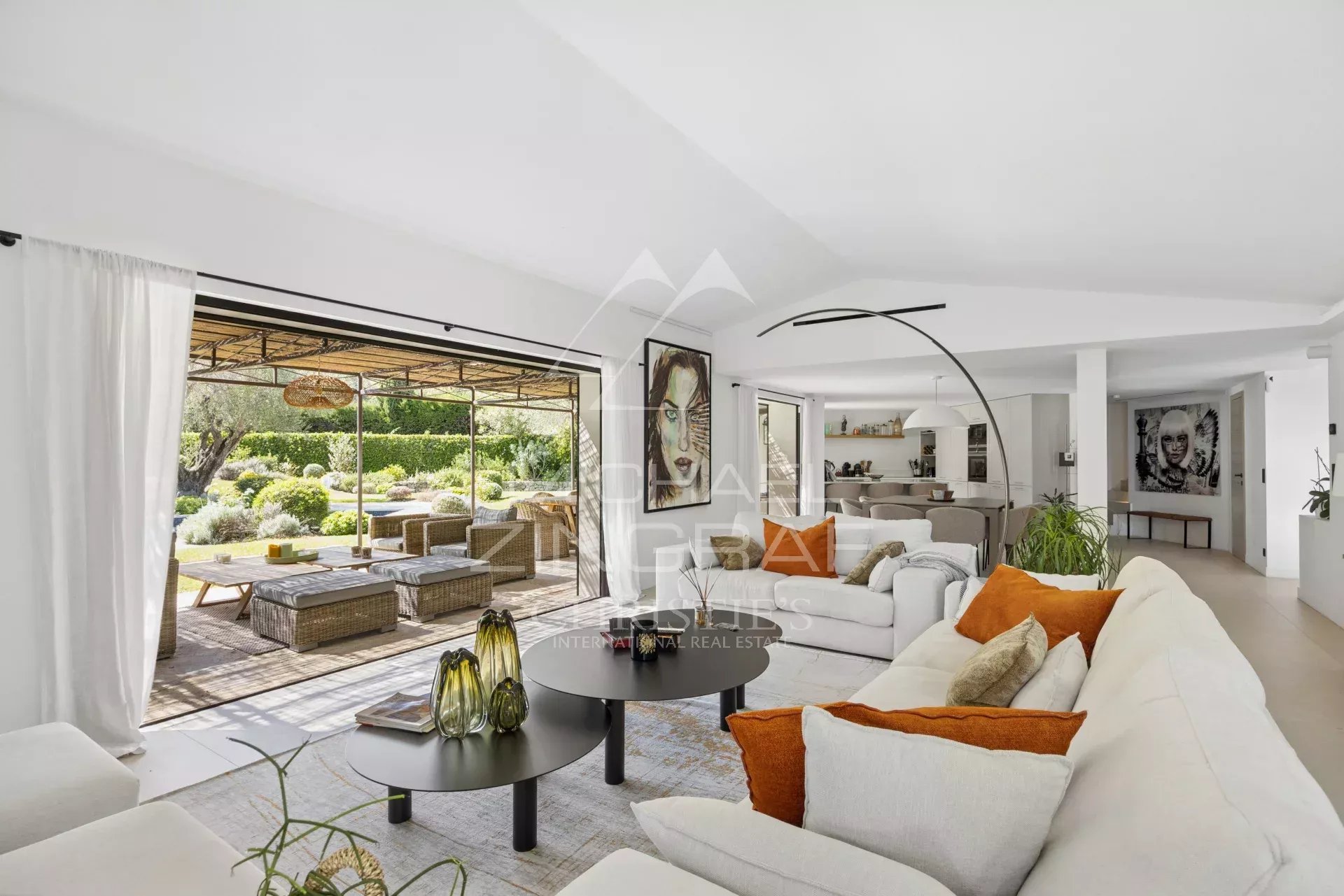 Intérieur d'une villa moderne avec salon lumineux et accès à une terrasse extérieure.