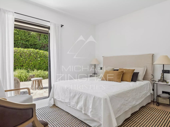 Chambre d'une villa avec accès à un jardin, décorée avec des matériaux de qualité.