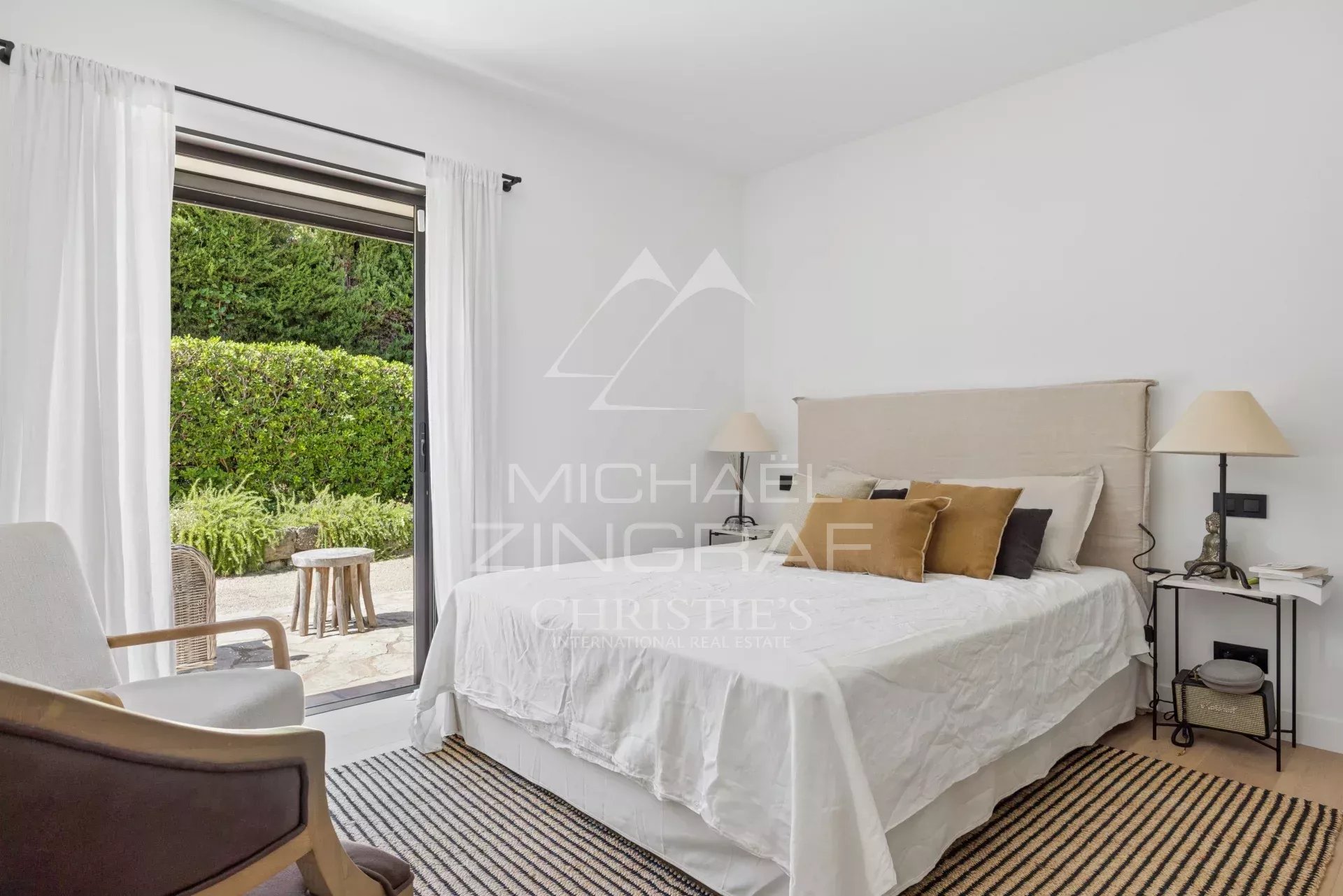 Chambre d'une villa avec accès à un jardin, décorée avec des matériaux de qualité.