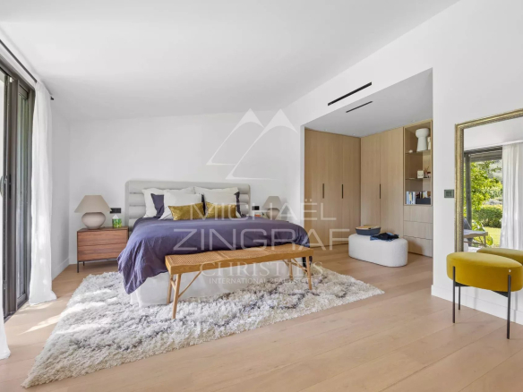 Chambre d'une villa familiale rénovée avec un mobilier moderne et un accès à l'extérieur.