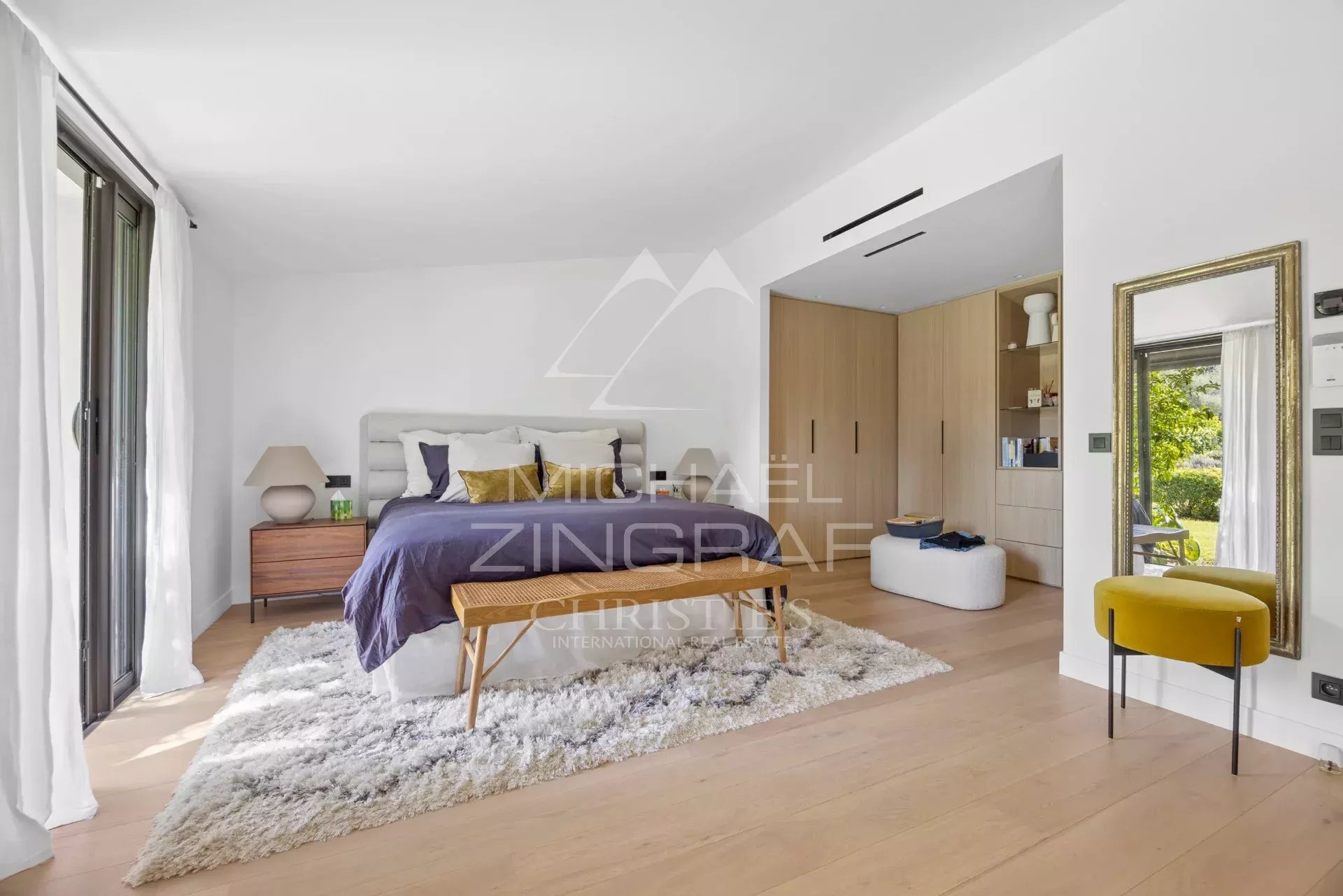 Chambre d'une villa familiale rénovée avec un mobilier moderne et un accès à l'extérieur.