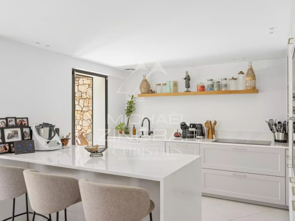 Cuisine moderne et lumineuse d'une villa rénovée avec un bar et des équipements de qualité.
