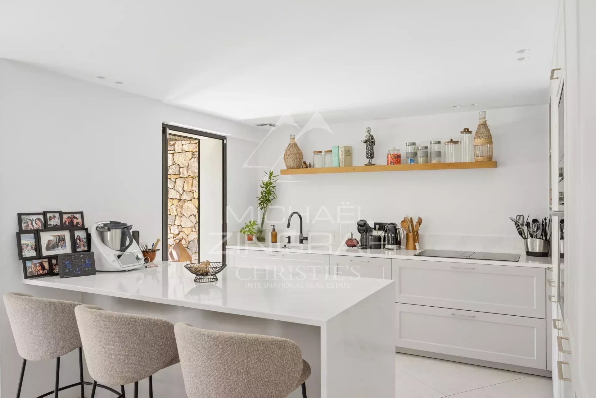 Cuisine moderne et lumineuse d'une villa rénovée avec un bar et des équipements de qualité.
